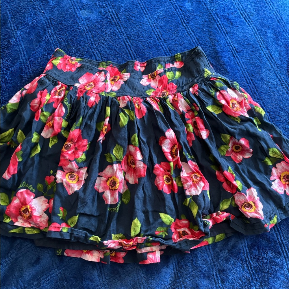 Juniors size S Hollister blue skirt with colorful flowers all over it
